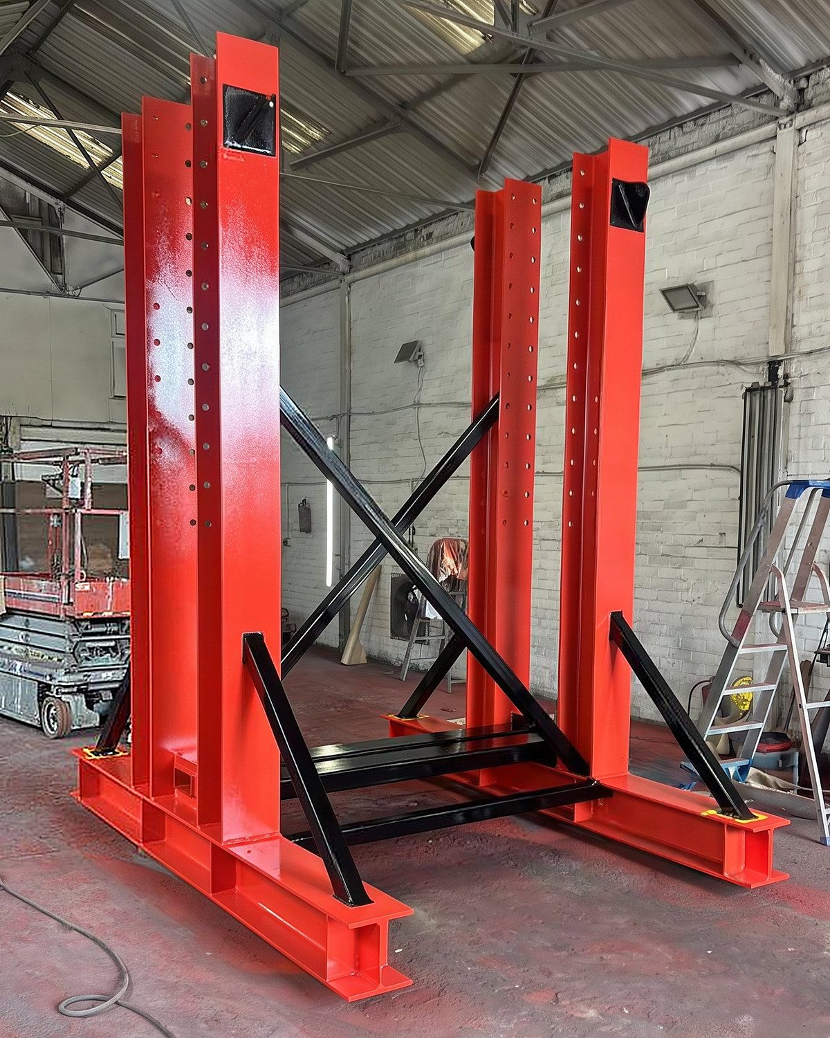 The frame built in the workshop, red uprights with black cross braces